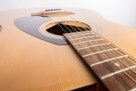 dreadnought six-string guitar made of light wood on a white background. an isolated object....