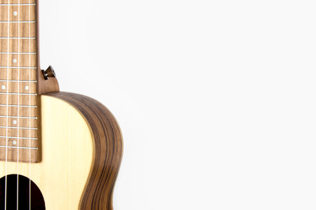 The guitar is made of beautiful wood. The ukulele. isolated. close-up. side view