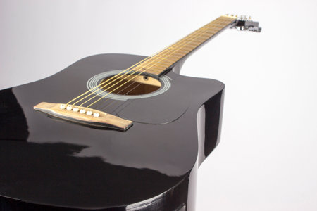 black acoustic guitar on a white background. an isolated object. close-up. view from below
