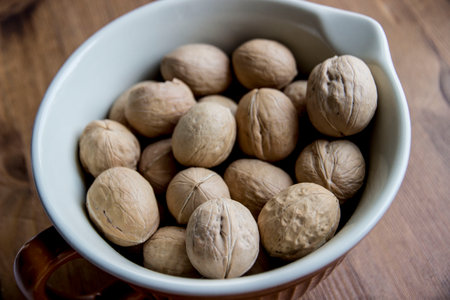 ripe walnuts in a white-cornered bowl. close-up