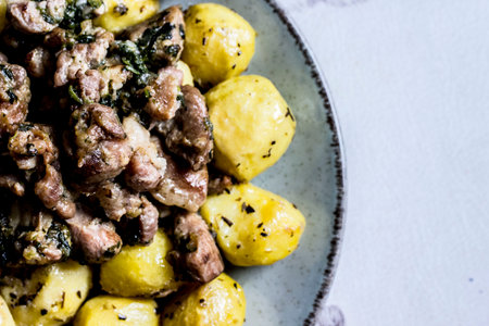 fried potatoes with meat on a plate. a place for a text or recipe. lifestyle, close-up. flat lay