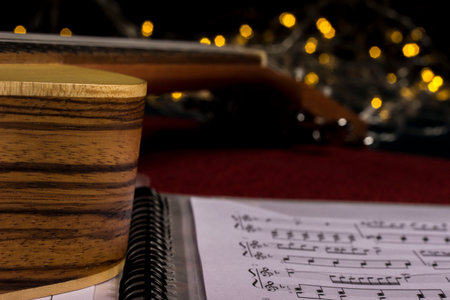ukulele with a music book on a blurred background with highlights. close-up. life style