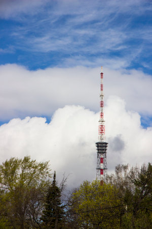 antenna on a background of white clouds and blue sky. a television tower. an internet transmitter.