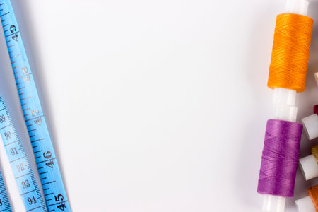 a tailor's centimeter or tapemeasure in blue and multicolored spools of thread.taken in close-up...