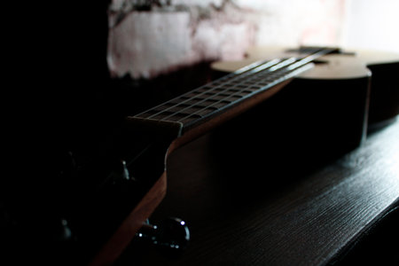 The strings of a six-string guitar shine in the dark. close-up photo in a dark key