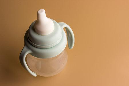 A bottle for feeding babies is taken in close-up on a light background
