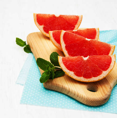 Grapefruit with mint on a old white wooden background