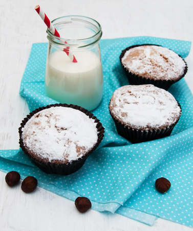 cupcakes and milk on a old white wooden backgroundの写真素材