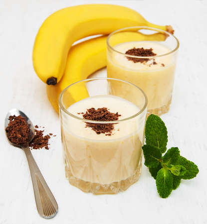 Banana smoothie with chocolate on a old white wooden backgroundの写真素材
