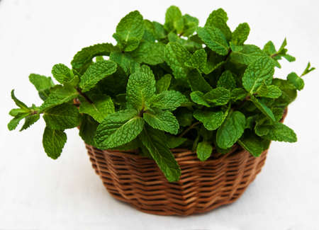 Mint in a basket on a old wooden backgroundの写真素材