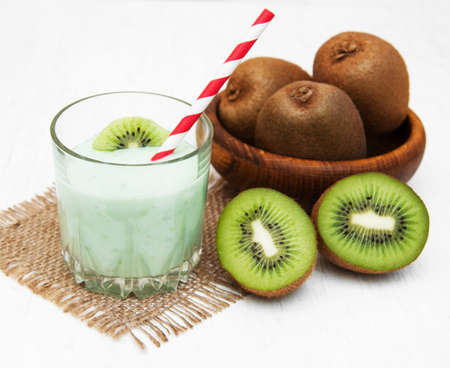 kiwi smoothie in glass on a old white wooden backgroundの写真素材