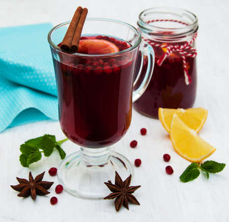 Glasses of mulled wine with lemon and cranberries on a old white wooden backgroundの写真素材