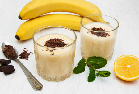 Banana smoothie with chocolate on a old white wooden backgroundの写真素材