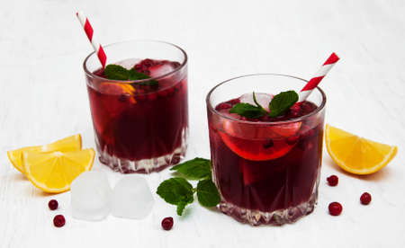 Glasses with cranberry cocktail on a old white wooden backgroundの写真素材