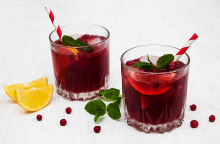 Glasses with cranberry cocktail on a old white wooden backgroundの写真素材