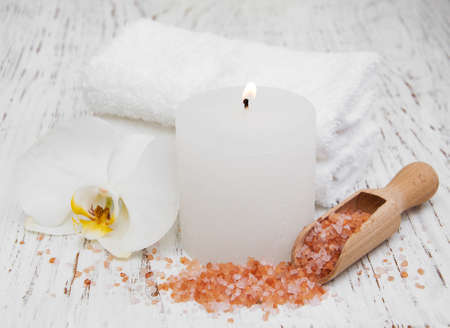 Candle, orcids and towels on a wooden backgroundの写真素材