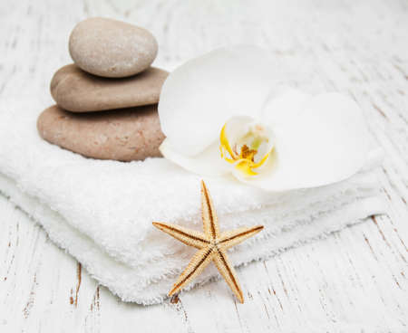 spa concept with stacked of stones starfish white flowers orchid and white towelsの写真素材