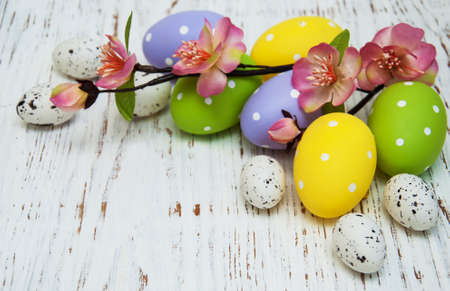 easter background with easter eggs  and flowers on a old wooden tableの写真素材