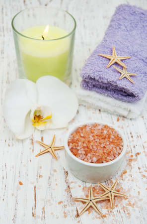 Candle, orcids and towels on a wooden backgroundの写真素材
