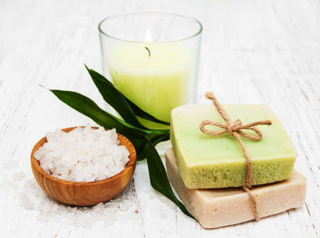 spa setting with candle, handmade soap and salt on a old wooden backgroundの写真素材