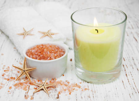 spa setting with  towels, candle and salt on a wooden backgroundの写真素材