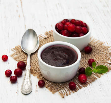 Cranberries jam with fresh berries on a wooden backgroundの写真素材