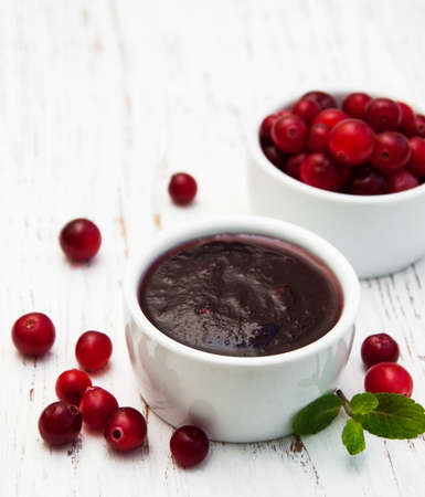 Cranberries jam with fresh berries on a wooden backgroundの写真素材