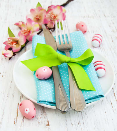 Easter table setting - quail eggs, plate on a old white wooden background