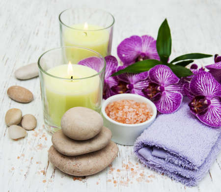Candles, orcids and towels on a wooden backgroundの写真素材