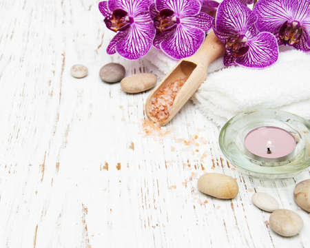 Candle, orcids and towels on a wooden backgroundの写真素材