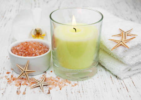 spa setting with orchid, towels, candle and salt on a wooden backgroundの写真素材