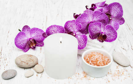 Candle, orcids and towels on a wooden backgroundの写真素材