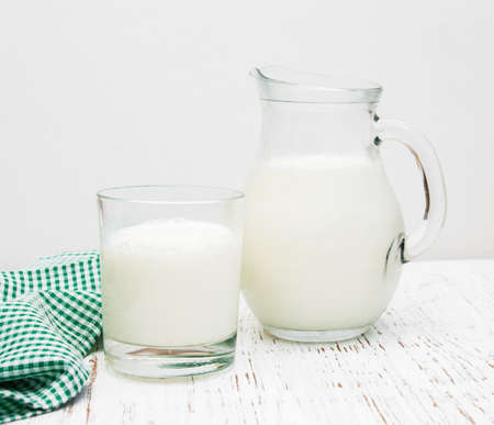 Jar and glass with fresh milk on a wooden backgroundの写真素材