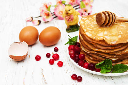 plate with pancakes with cranberries on a wooden backgroundの写真素材
