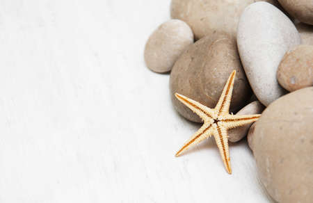 pebbles and starfish on a old white wooden backgroundの写真素材
