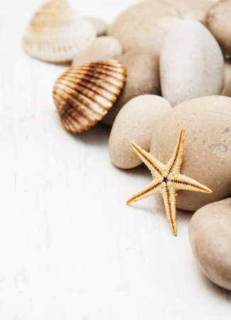 pebbles and starfish on a old white wooden backgroundの写真素材