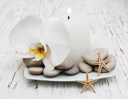 Spa set - candle, orchid flower and pebble on a wooden backgroundの写真素材