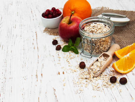 oatmeal with apple and oranges on a wooden backgroundの写真素材