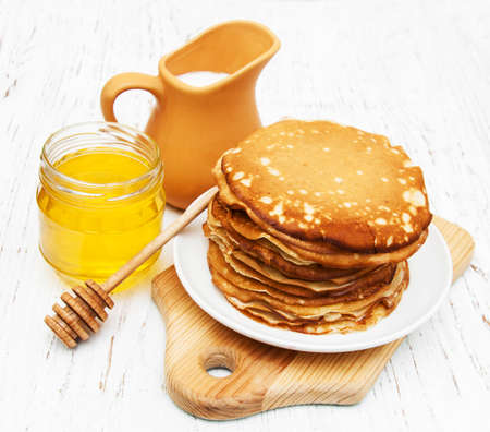 Pancakes with milk and honey on a wooden backgroundの写真素材