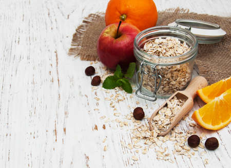 oatmeal with apple and oranges on a wooden backgroundの写真素材