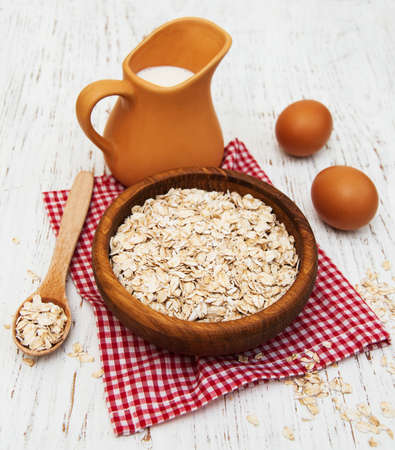 bowl of oat flake and milk on a wooden backgroundの写真素材