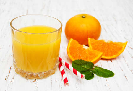 Orange juice with fresh fruits on a wooden backgroundの写真素材