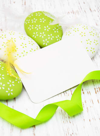 Easter greeting card with easter eggs on a old wooden backgroundの写真素材