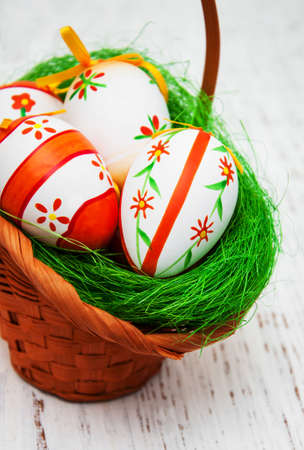 Easter eggs in a basket on a old wooden backgroundの写真素材