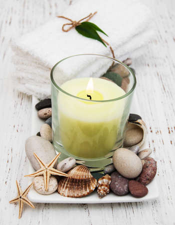 Spa setting with candle, pebble with starfish and towelsの写真素材