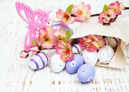 Easter eggs with flowers package of paper on a old wooden background