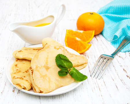 Pancakes with oranges on a old wooden tableの写真素材