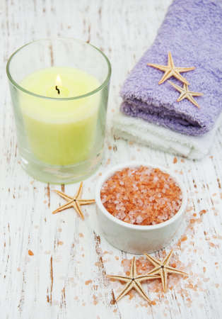 spa setting with towels, candle and salt on a wooden backgroundの写真素材