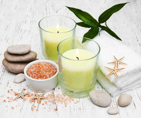 spa setting with  towels, candle and salt on a wooden backgroundの写真素材