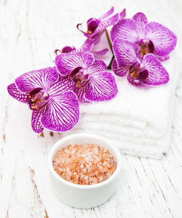 Pink Orchids with towel and massage salt on a wooden backgroundの写真素材
